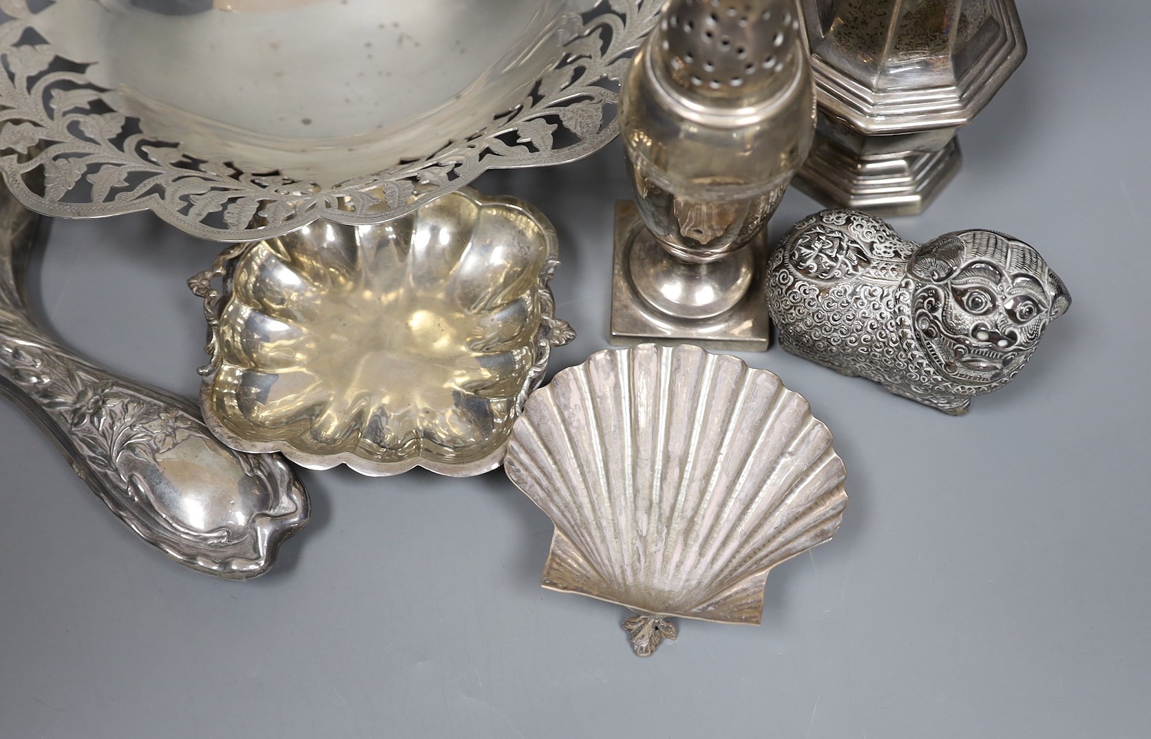 Mixed silver and white metal items including two silver casters, a silver mounted hand mirror, an Egyptian pierced dish, two small dishes and a lion box and cover.